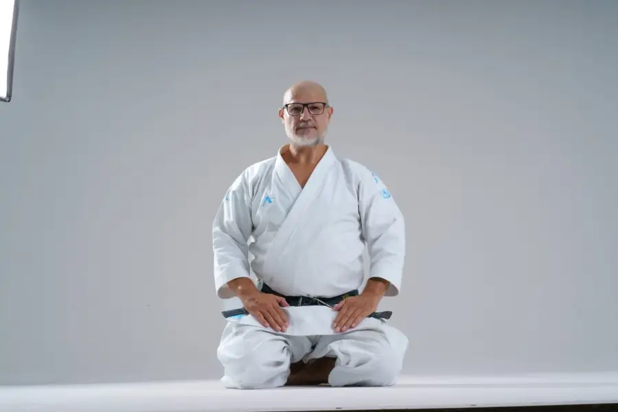 Sensei Oliver Dobre în seiza, ținând centura neagră
